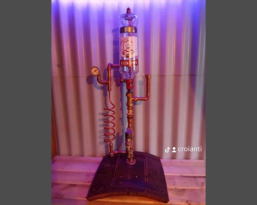 Single copper spirit dispenser on an oak barrel base